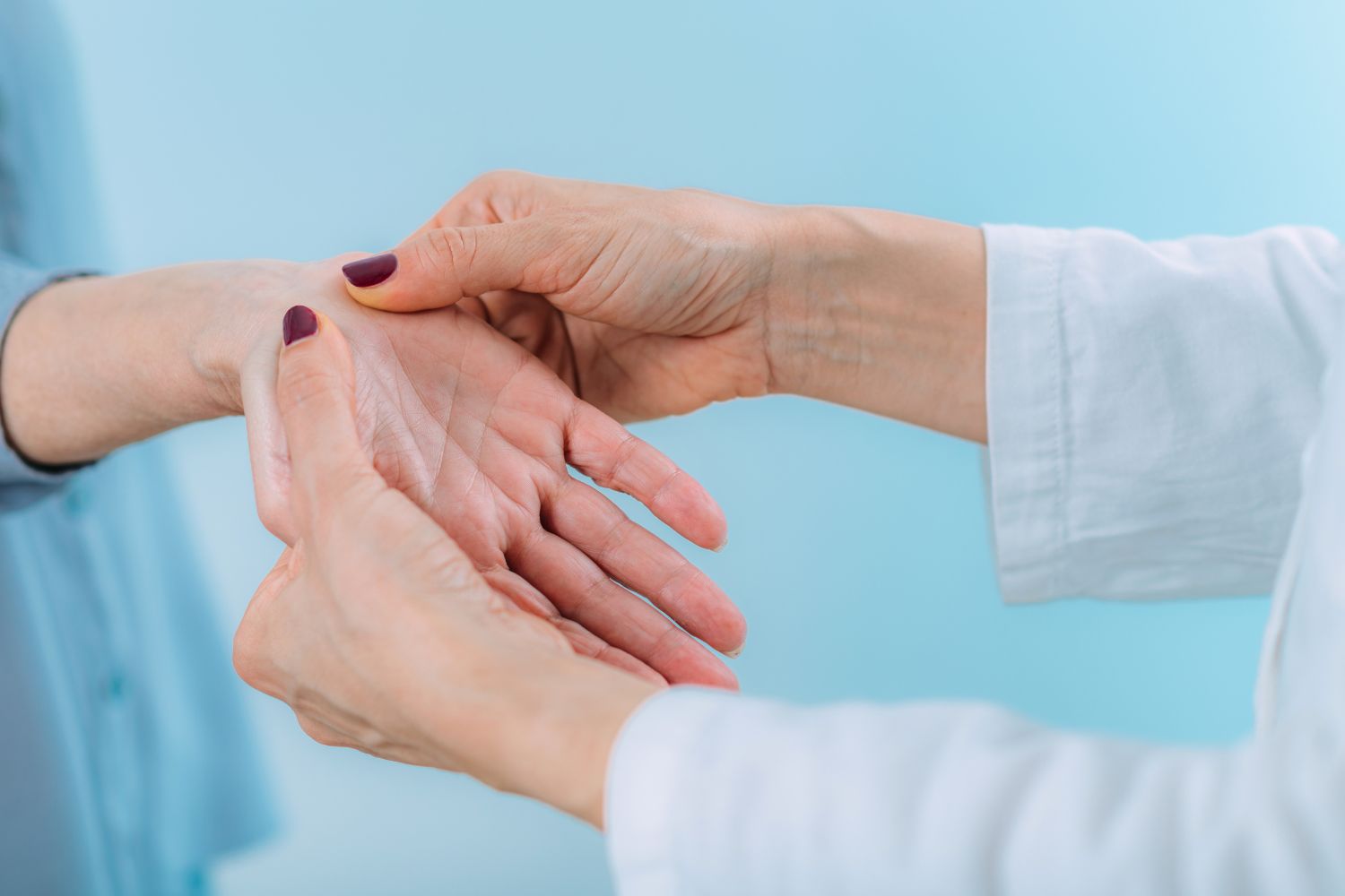 doctor checking a patient's hand to assess carpal tunnel symptoms and recommend self care tips